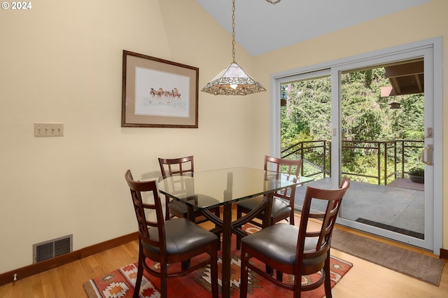 dining space featuring wood-type flooring and lofted ceiling