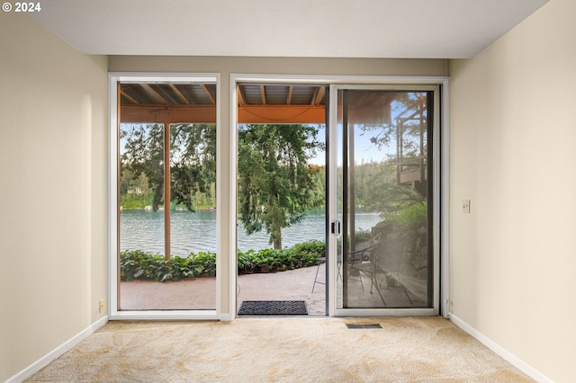 entryway featuring a water view and carpet flooring