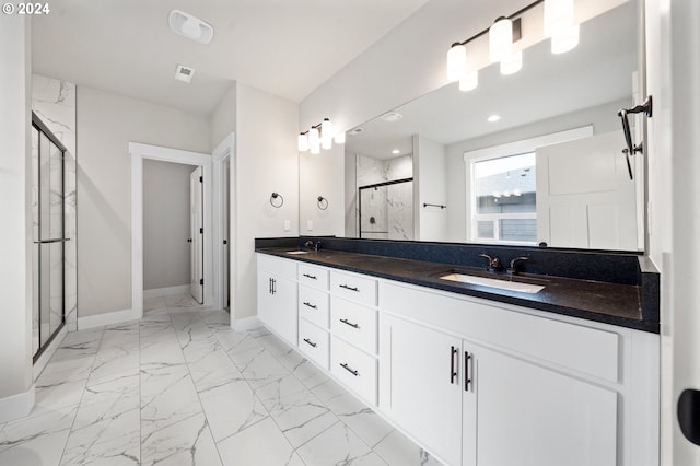 bathroom featuring a shower with door and vanity