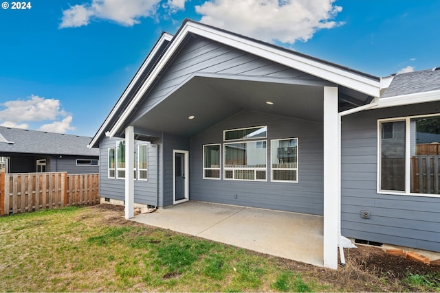 rear view of property with a lawn and a patio