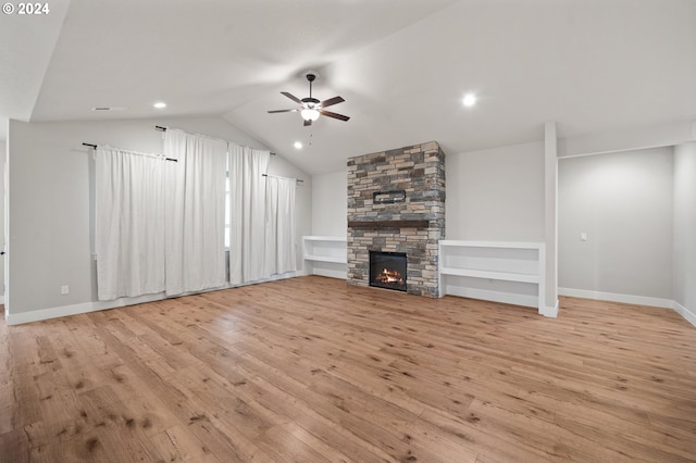 unfurnished living room with ceiling fan, a fireplace, light hardwood / wood-style floors, and lofted ceiling