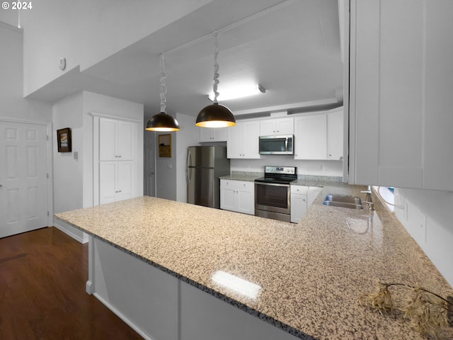 kitchen with kitchen peninsula, appliances with stainless steel finishes, dark hardwood / wood-style floors, and white cabinetry