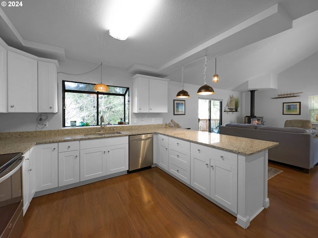 kitchen featuring dishwasher, white cabinetry, a wood stove, and kitchen peninsula