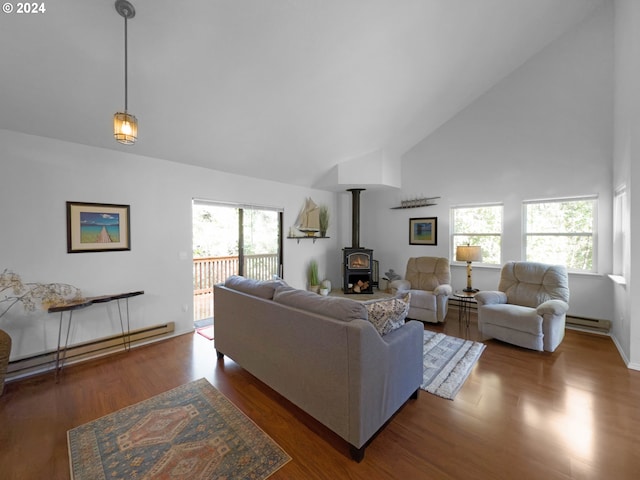 living room with a wood stove, dark wood-type flooring, a healthy amount of sunlight, and a baseboard radiator