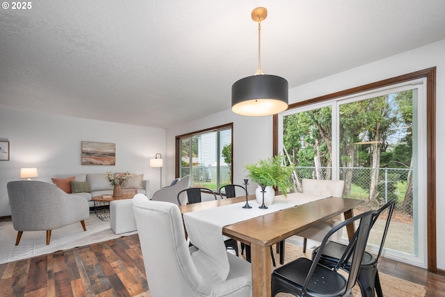 dining space featuring a textured ceiling and dark wood-style flooring