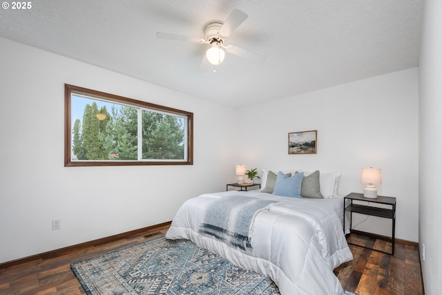 bedroom featuring visible vents, a ceiling fan, a textured ceiling, wood finished floors, and baseboards