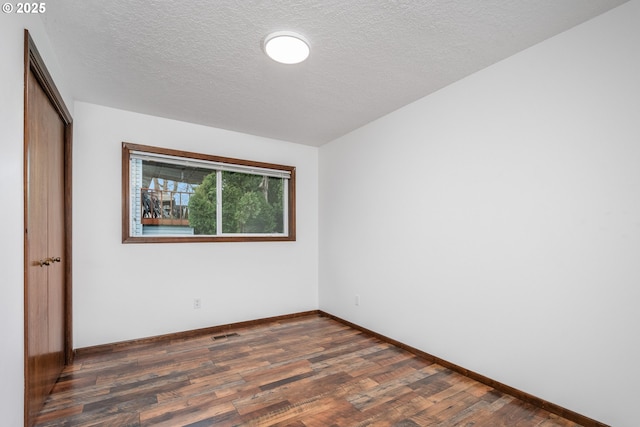 unfurnished bedroom with visible vents, a textured ceiling, wood finished floors, a closet, and baseboards