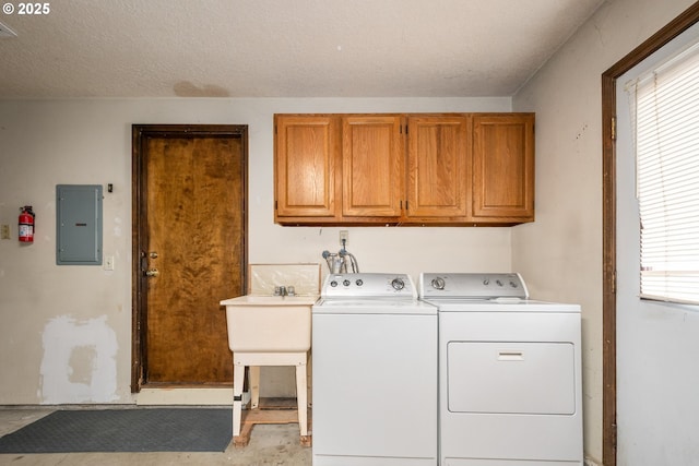 laundry room featuring electric panel, cabinet space, a healthy amount of sunlight, and washing machine and clothes dryer