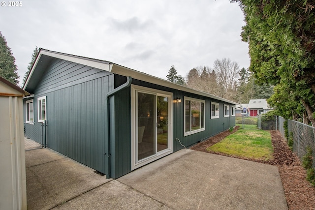 rear view of property with a patio area, a gate, a yard, and fence