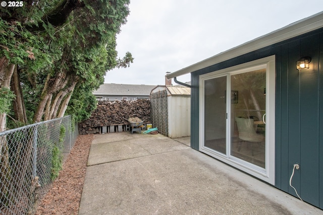 view of patio with a storage shed, an outbuilding, and a fenced backyard