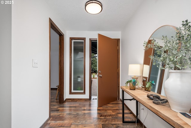 hall with dark wood-style floors and a textured ceiling