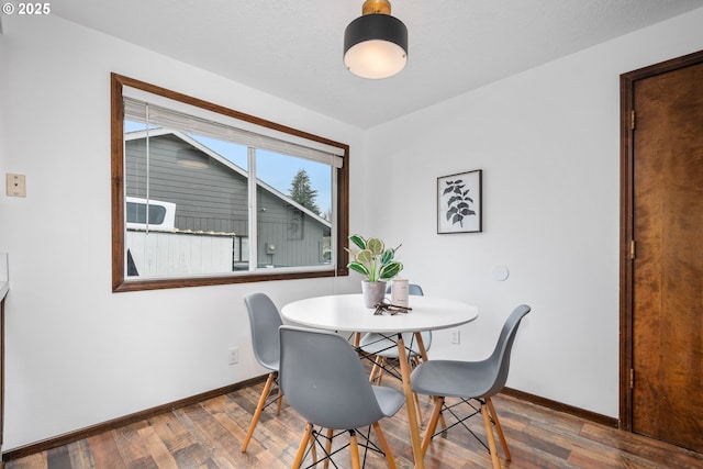 dining area featuring baseboards and wood finished floors