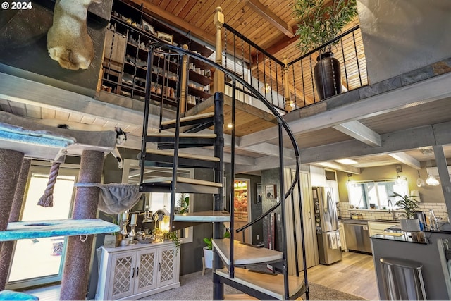 stairs with beamed ceiling, hardwood / wood-style floors, and wood ceiling