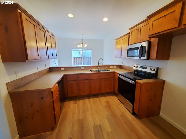 kitchen featuring sink, stainless steel appliances, a chandelier, decorative light fixtures, and light wood-type flooring