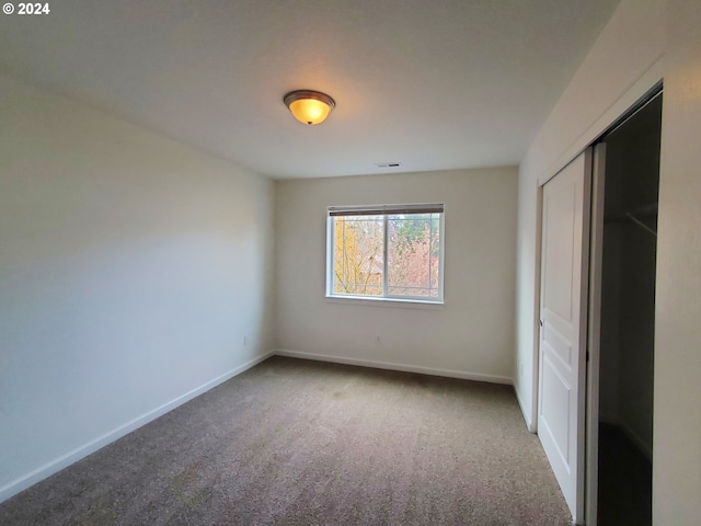 unfurnished bedroom featuring carpet and a closet