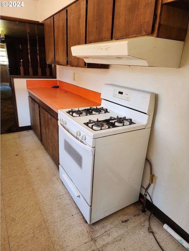 kitchen with white gas range and light tile flooring