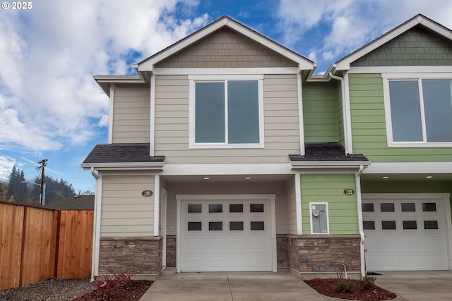 craftsman inspired home featuring fence, stone siding, concrete driveway, and a garage