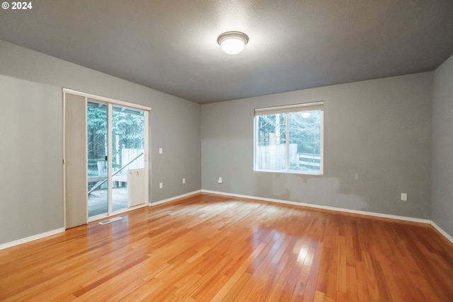 spare room featuring hardwood / wood-style floors and plenty of natural light