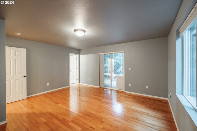 spare room with light hardwood / wood-style flooring and a textured ceiling