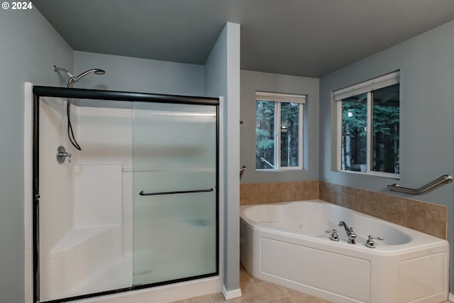 bathroom with tile patterned flooring and shower with separate bathtub