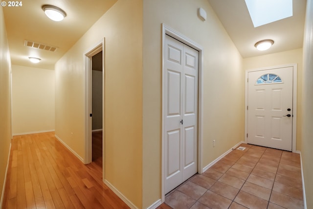 interior space with light hardwood / wood-style floors and a skylight