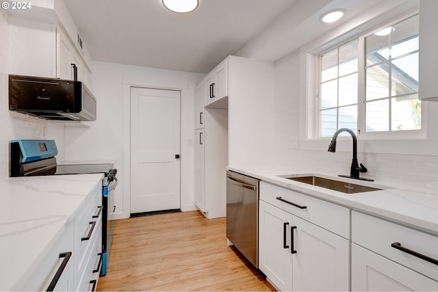 kitchen featuring white cabinetry, dishwasher, sink, range with electric stovetop, and light hardwood / wood-style floors