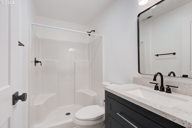 bathroom with a shower, vanity, and toilet