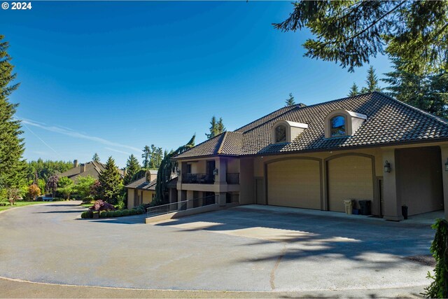 27050 SW Petes Mountain Rd, West Linn, OR 97068 - view of front of property featuring a garage, stucco siding, a tiled roof, and driveway