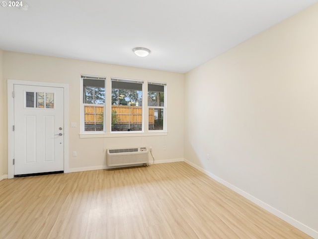 interior space with light hardwood / wood-style floors and an AC wall unit