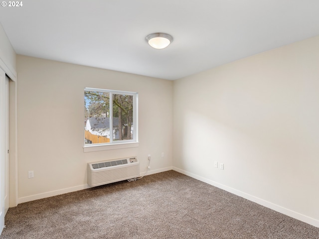 carpeted empty room featuring a wall unit AC