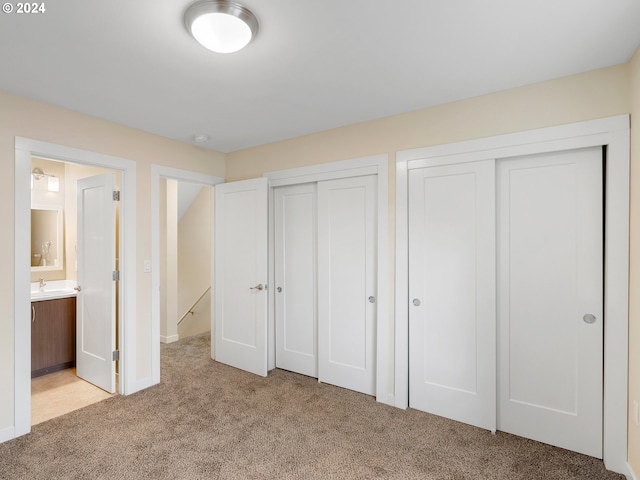 unfurnished bedroom with light carpet and ensuite bath