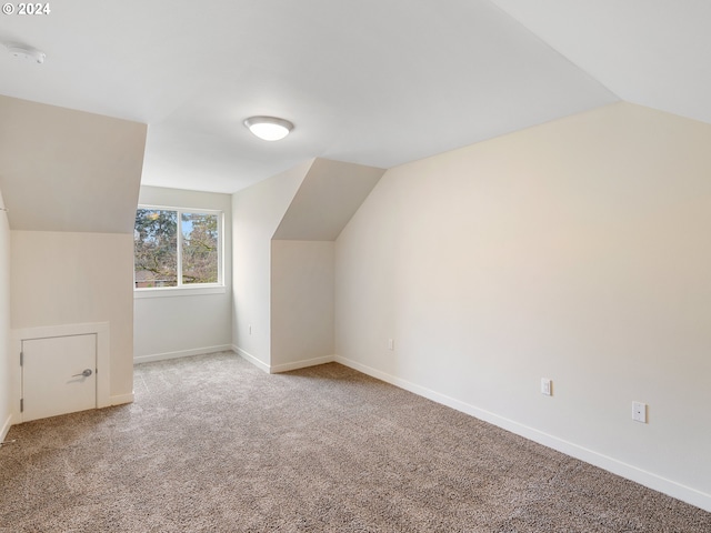 additional living space with carpet floors and vaulted ceiling