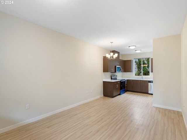 kitchen featuring sink, stainless steel appliances, a notable chandelier, dark brown cabinets, and light wood-type flooring