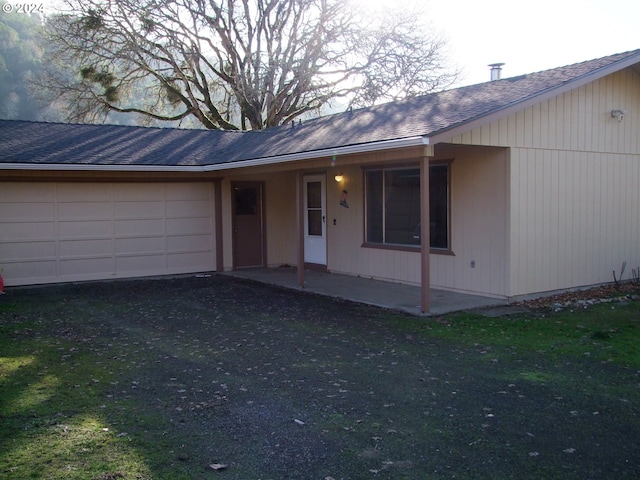 ranch-style house featuring a patio, a front yard, and a garage