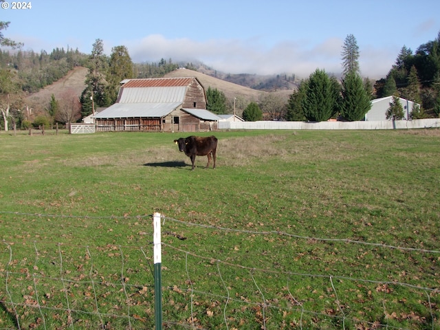 view of yard with a rural view and an outdoor structure