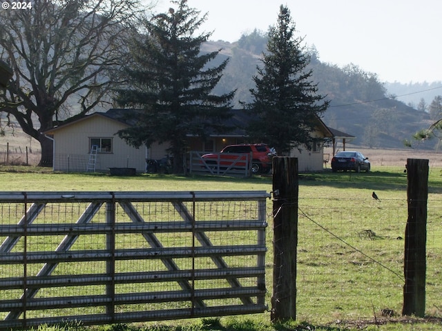 view of gate featuring a mountain view and a yard