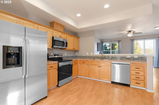 kitchen with ceiling fan, sink, light wood-type flooring, light brown cabinets, and stainless steel appliances