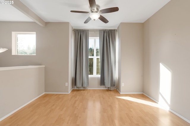 spare room featuring ceiling fan, light wood-type flooring, and beamed ceiling