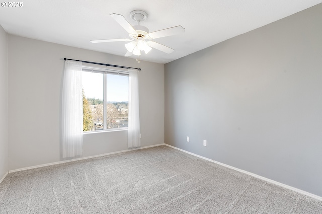 carpeted spare room featuring ceiling fan