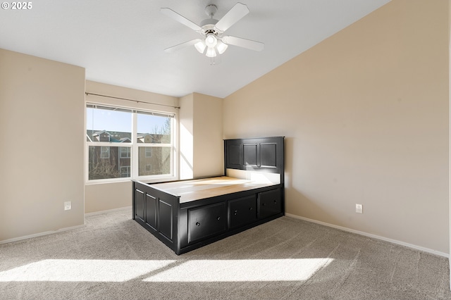 unfurnished bedroom featuring light carpet, ceiling fan, and lofted ceiling