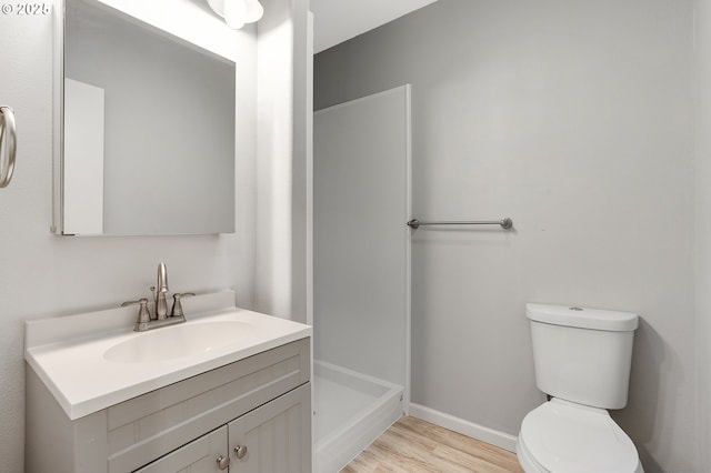 bathroom featuring toilet, vanity, and hardwood / wood-style flooring