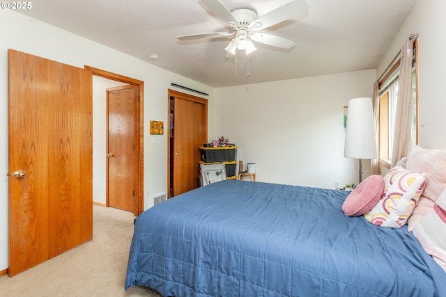 bedroom with light carpet, a closet, and ceiling fan