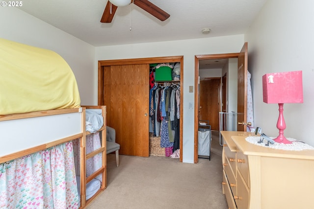 bedroom with ceiling fan, a closet, and light carpet