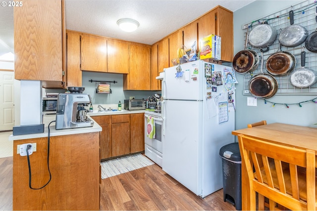 kitchen with white appliances, dark hardwood / wood-style flooring, and sink