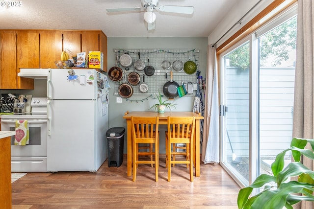 kitchen with ceiling fan, a textured ceiling, white appliances, and light hardwood / wood-style floors