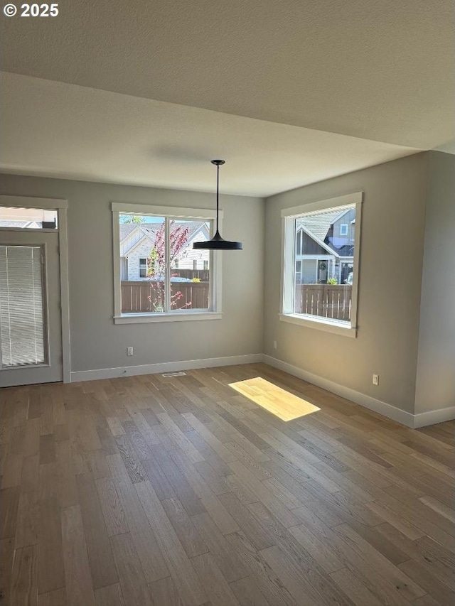 1918 S Holly St, Canby, OR 97013 - unfurnished dining area featuring wood finished floors, a chandelier, baseboards, and a textured ceiling