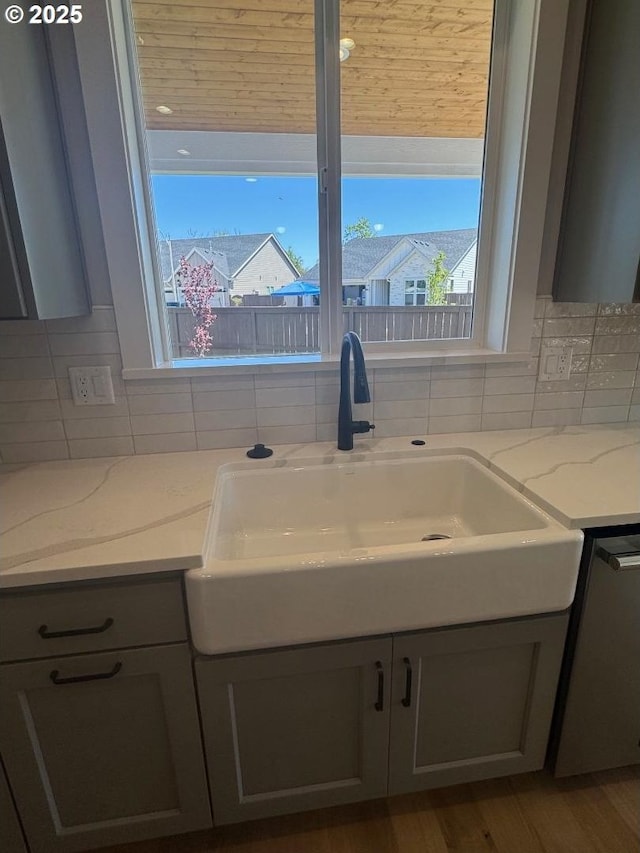 1918 S Holly St, Canby, OR 97013 - kitchen with wall chimney range hood, appliances with stainless steel finishes, gray cabinets, tasteful backsplash, and light stone countertops
