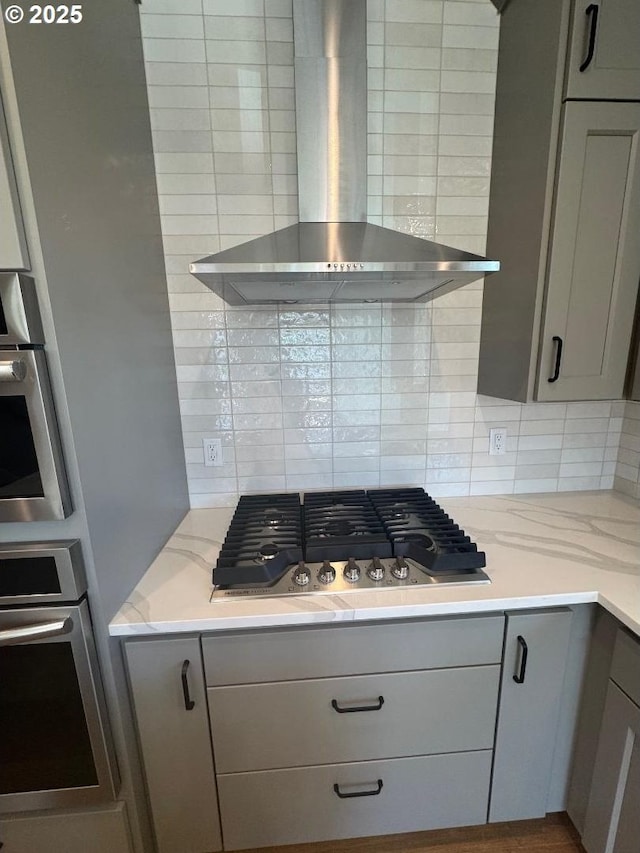 1918 S Holly St, Canby, OR 97013 - kitchen featuring gray cabinetry, light wood-type flooring, stainless steel appliances, light stone countertops, and wall chimney range hood
