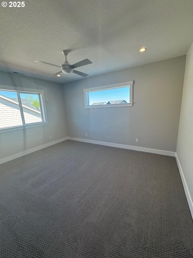 1918 S Holly St, Canby, OR 97013 - empty room featuring plenty of natural light, a textured ceiling, ceiling fan, baseboards, and dark carpet
