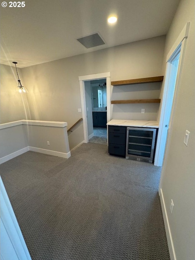 1918 S Holly St, Canby, OR 97013 - unfurnished living room with wine cooler, dark colored carpet, baseboards, and a dry bar